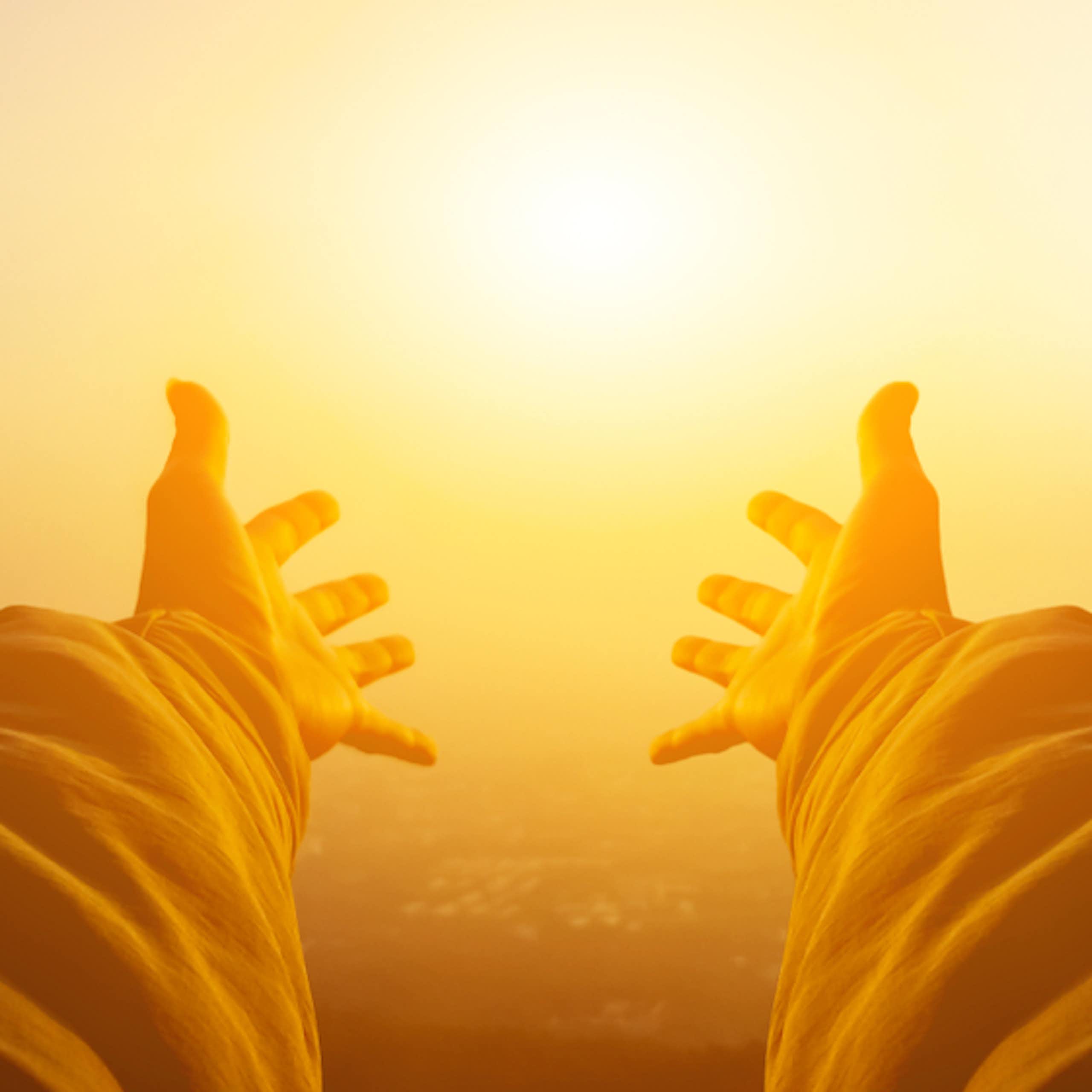 Pair of outstretched arms reaching towards Sun