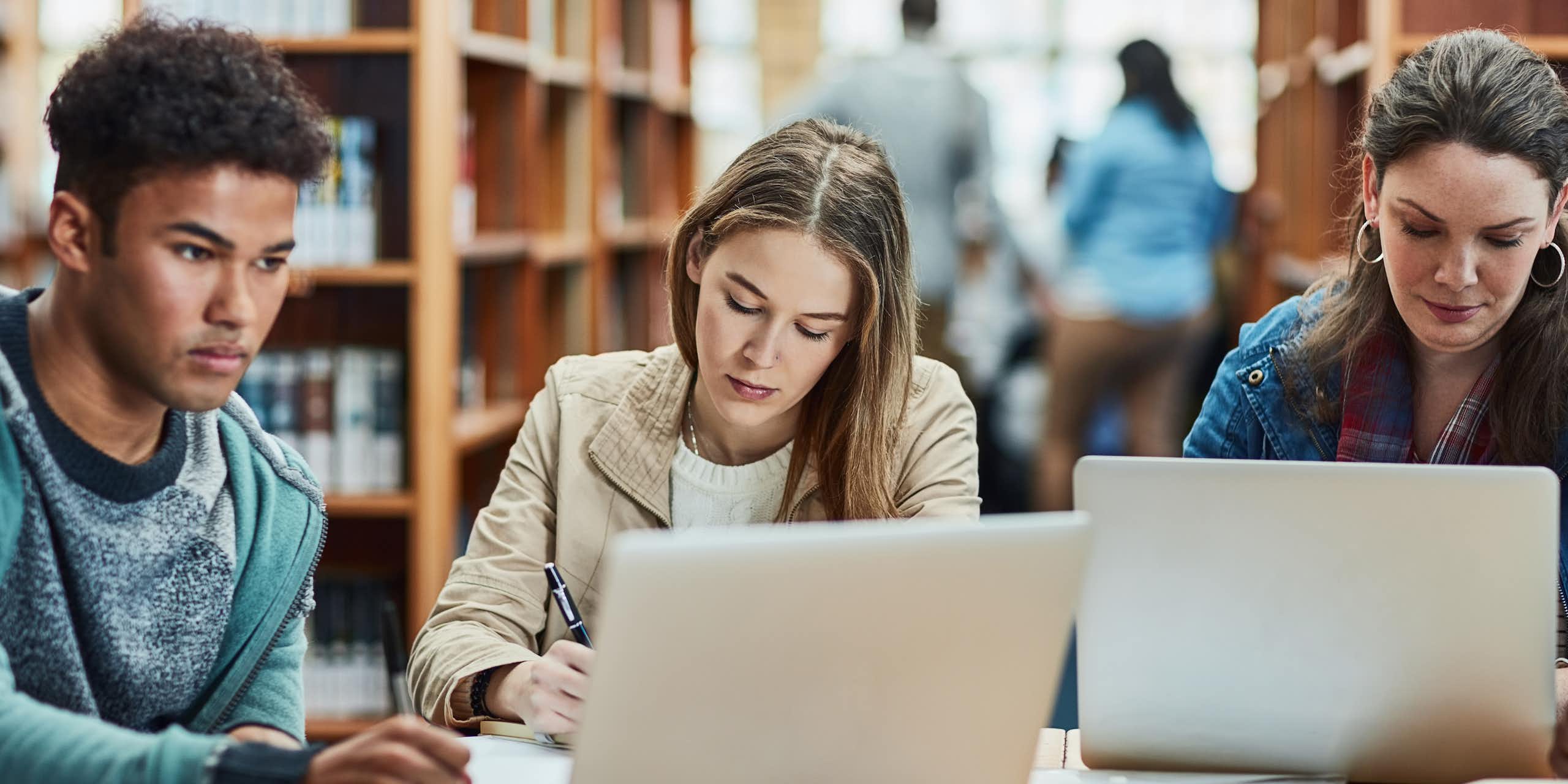 Trois jeunes étudient à la bibliothèque