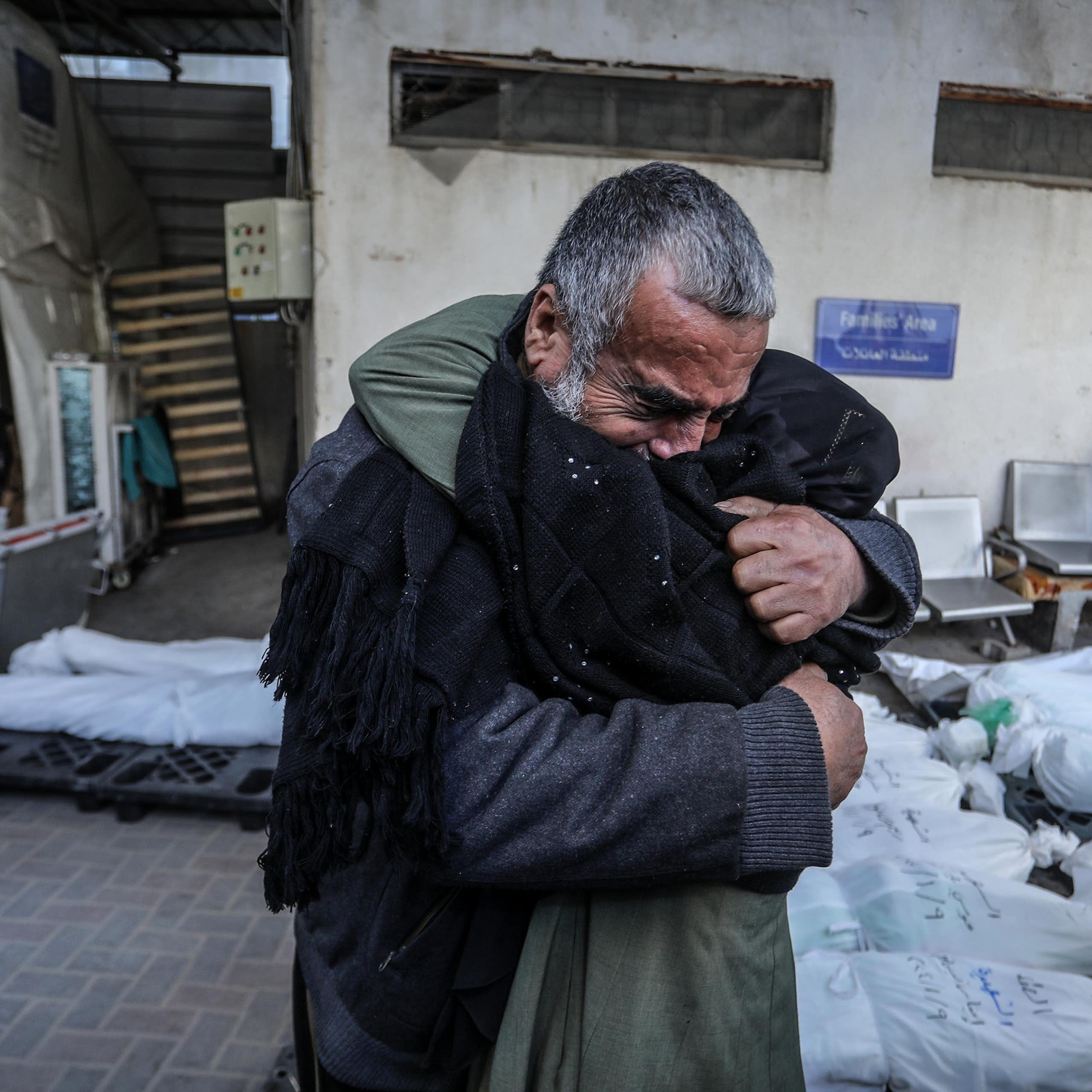 Two people hugging on the street.