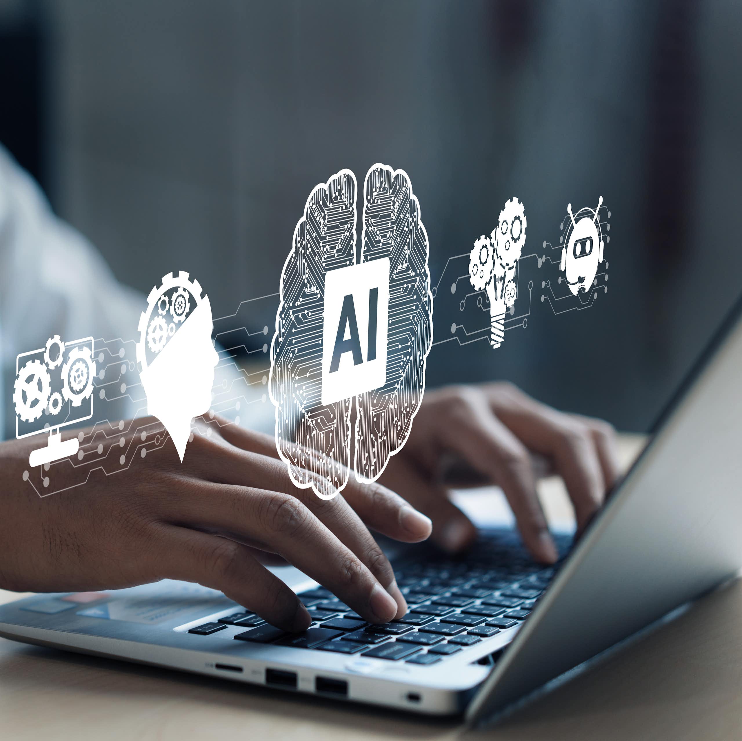 A pair of hands type on the keyboard of an open laptop with images of gear and brains float above it