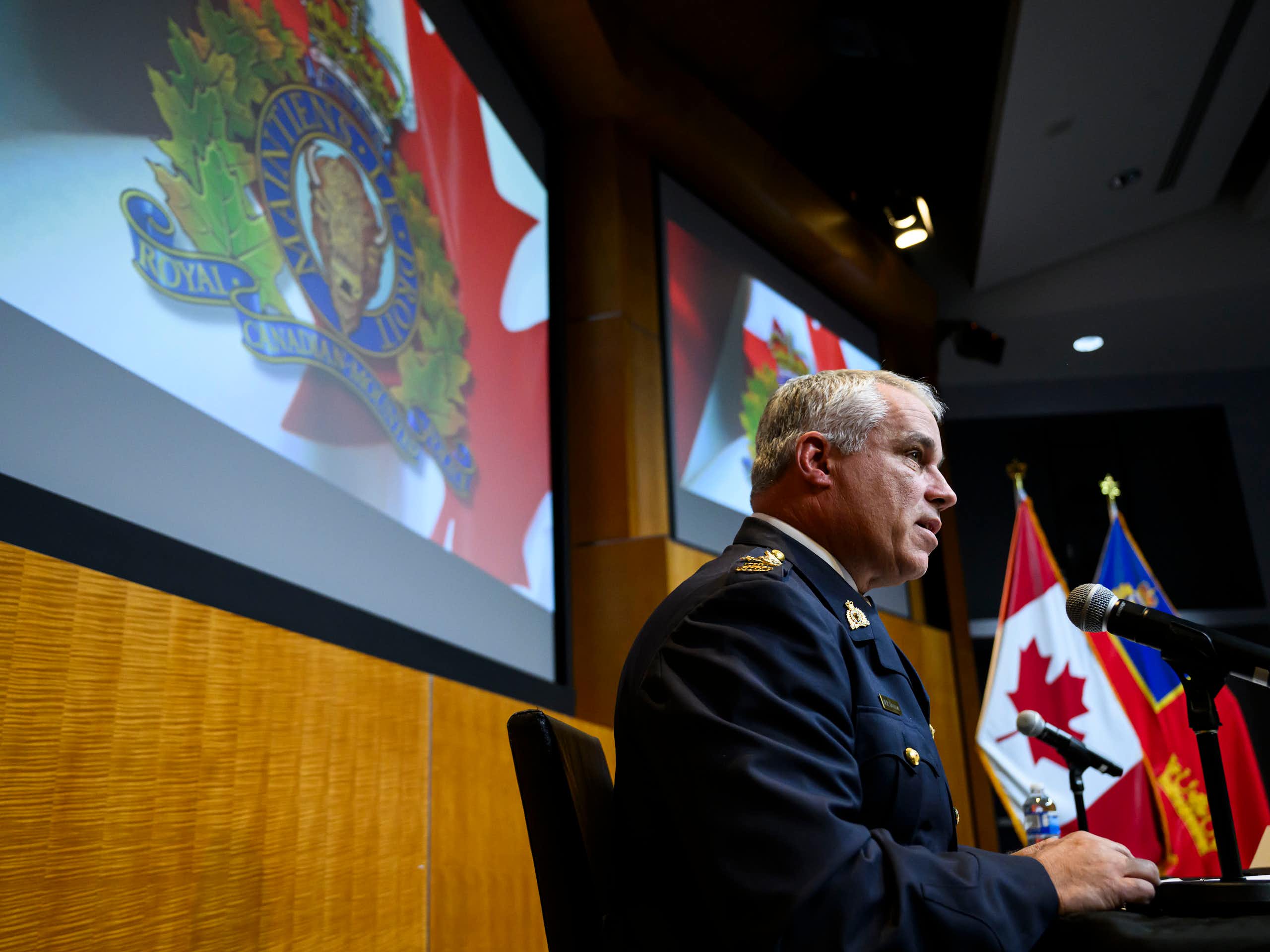 A man in a uniform speaks into a microphone.