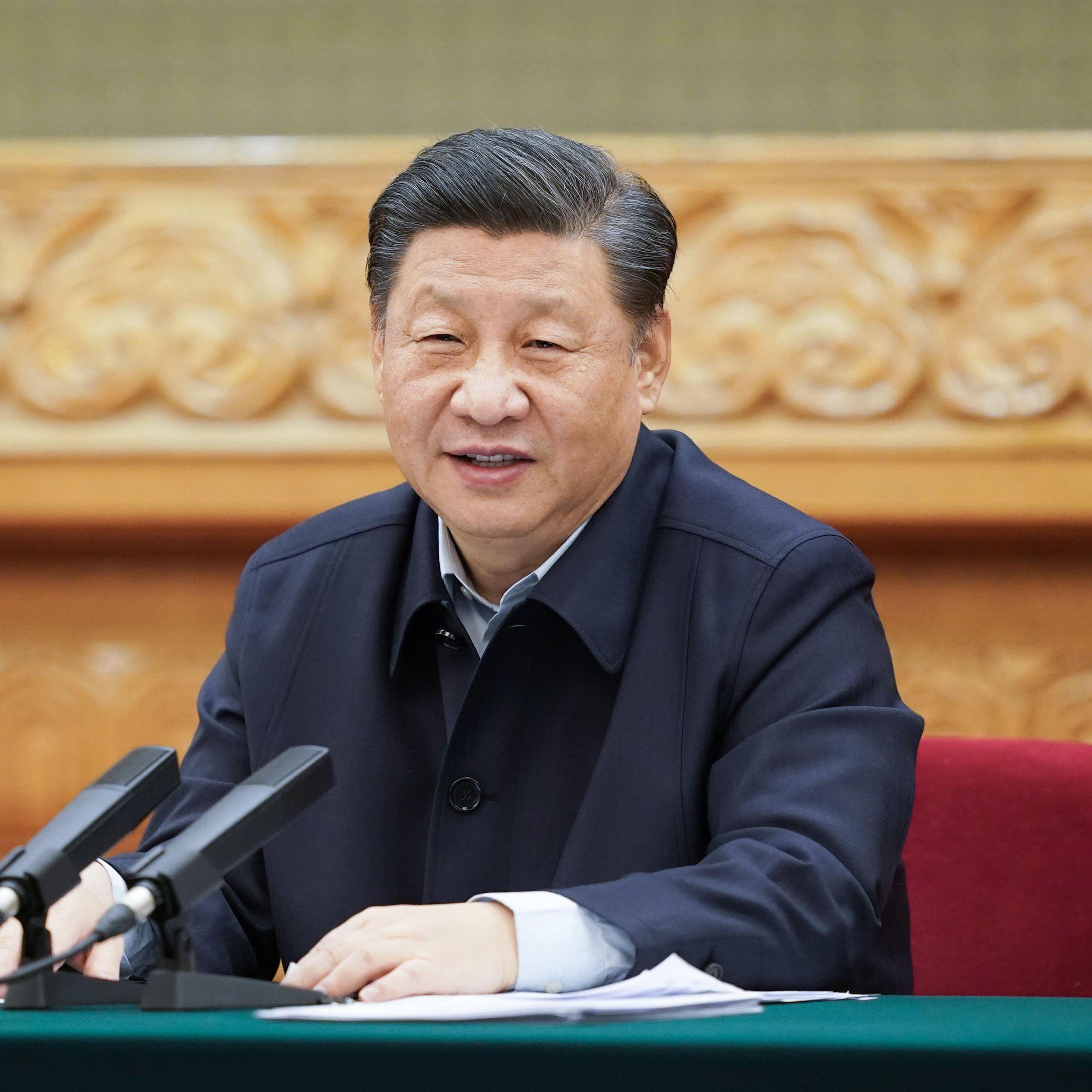 China's President Xi sitting at a desk.