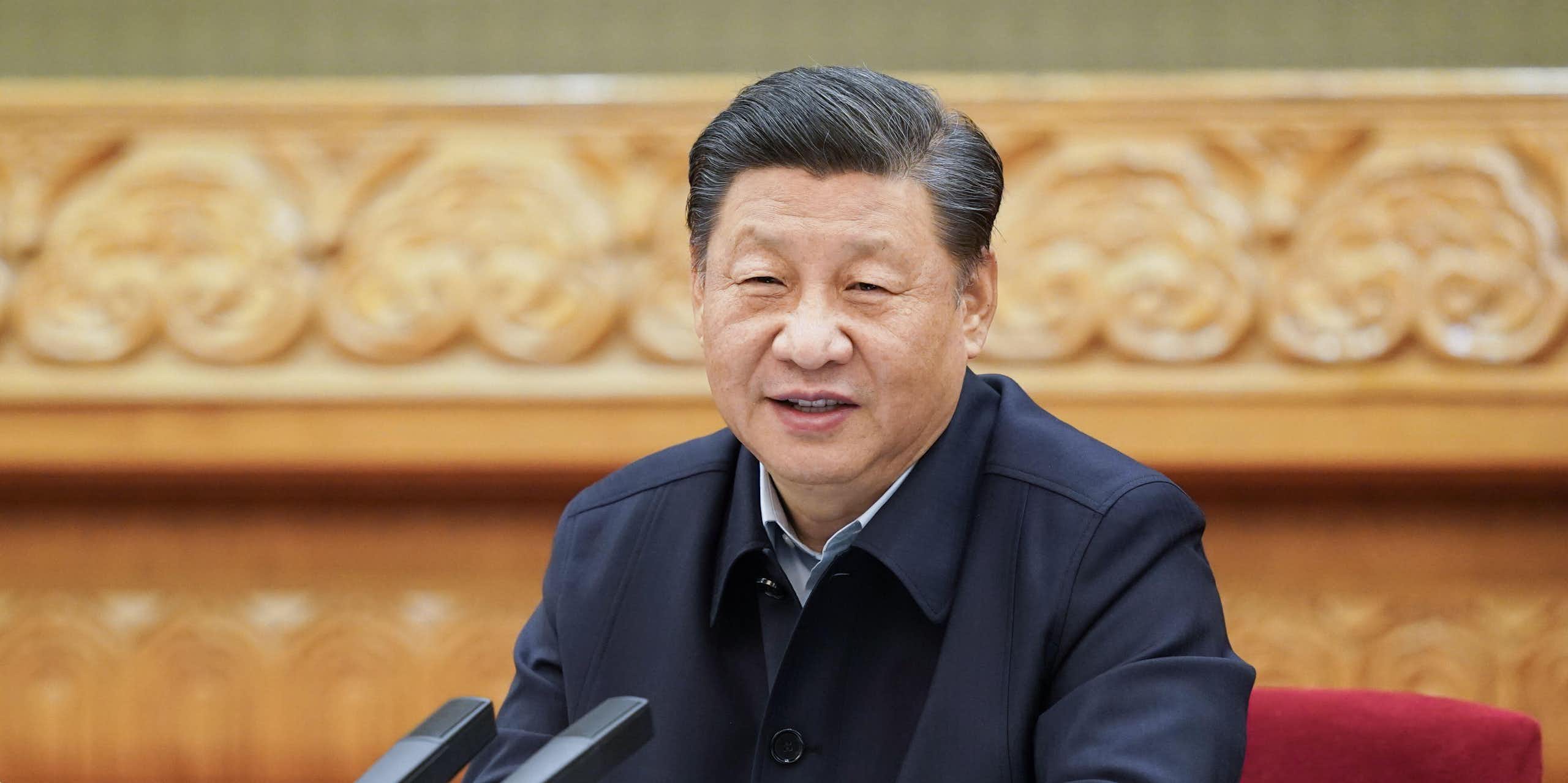 China's President Xi sitting at a desk.