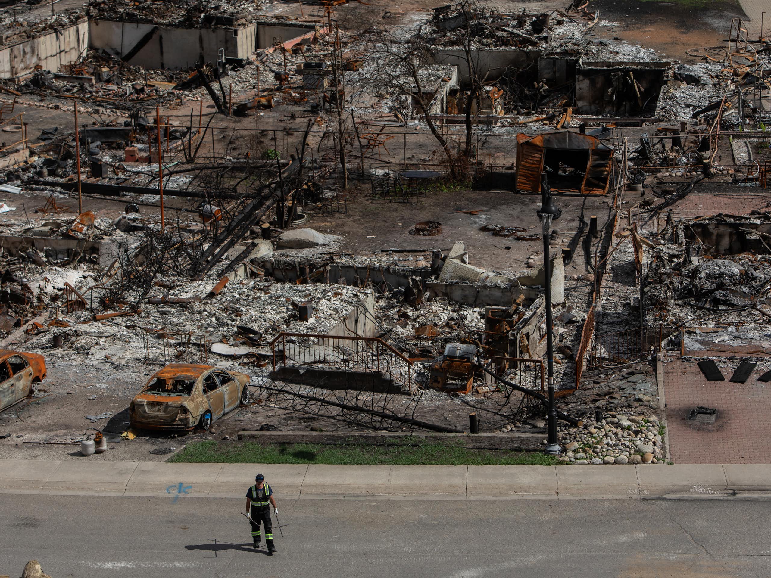 a worker observes a burned out neighbourhood