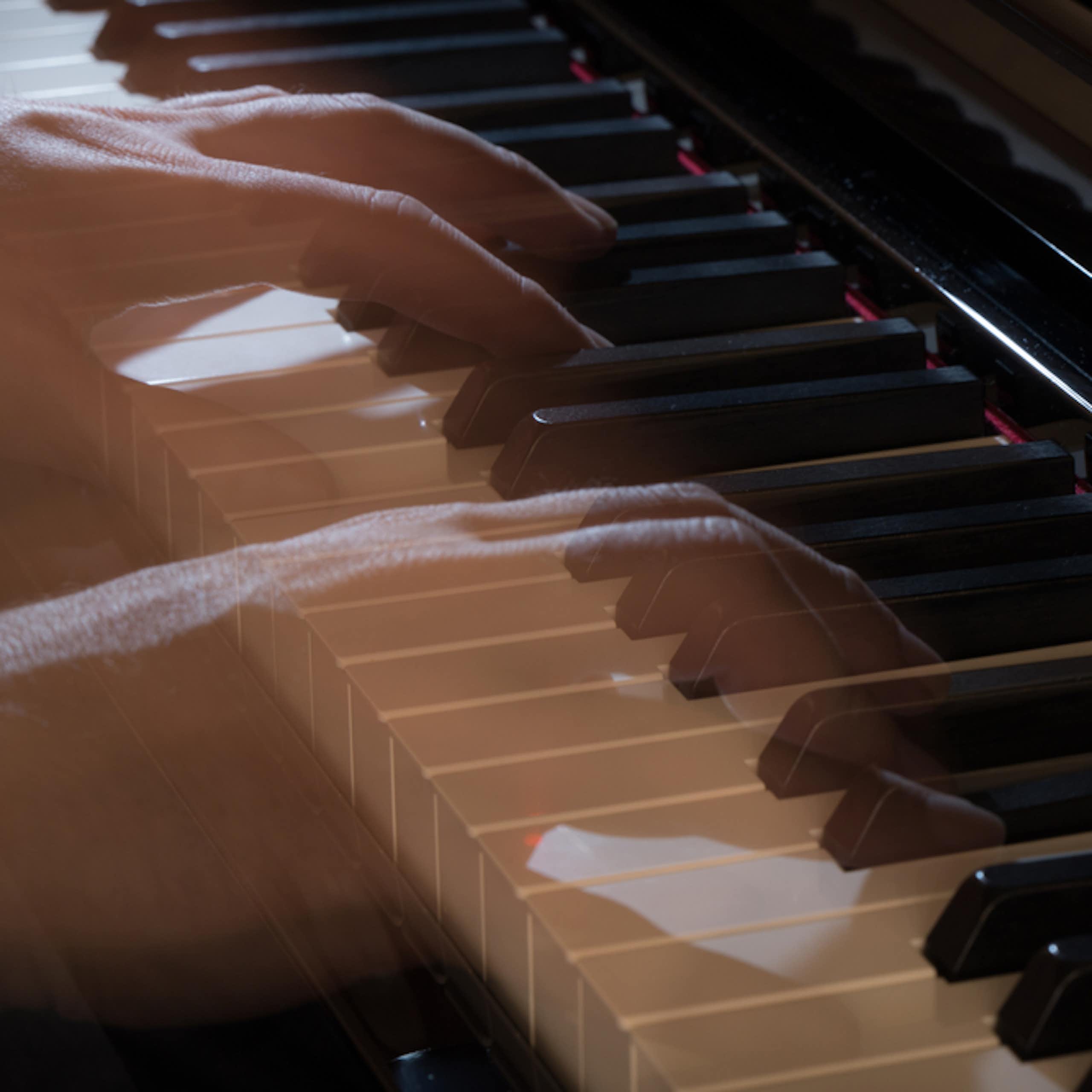 See-through, ghostly hands play a piano.