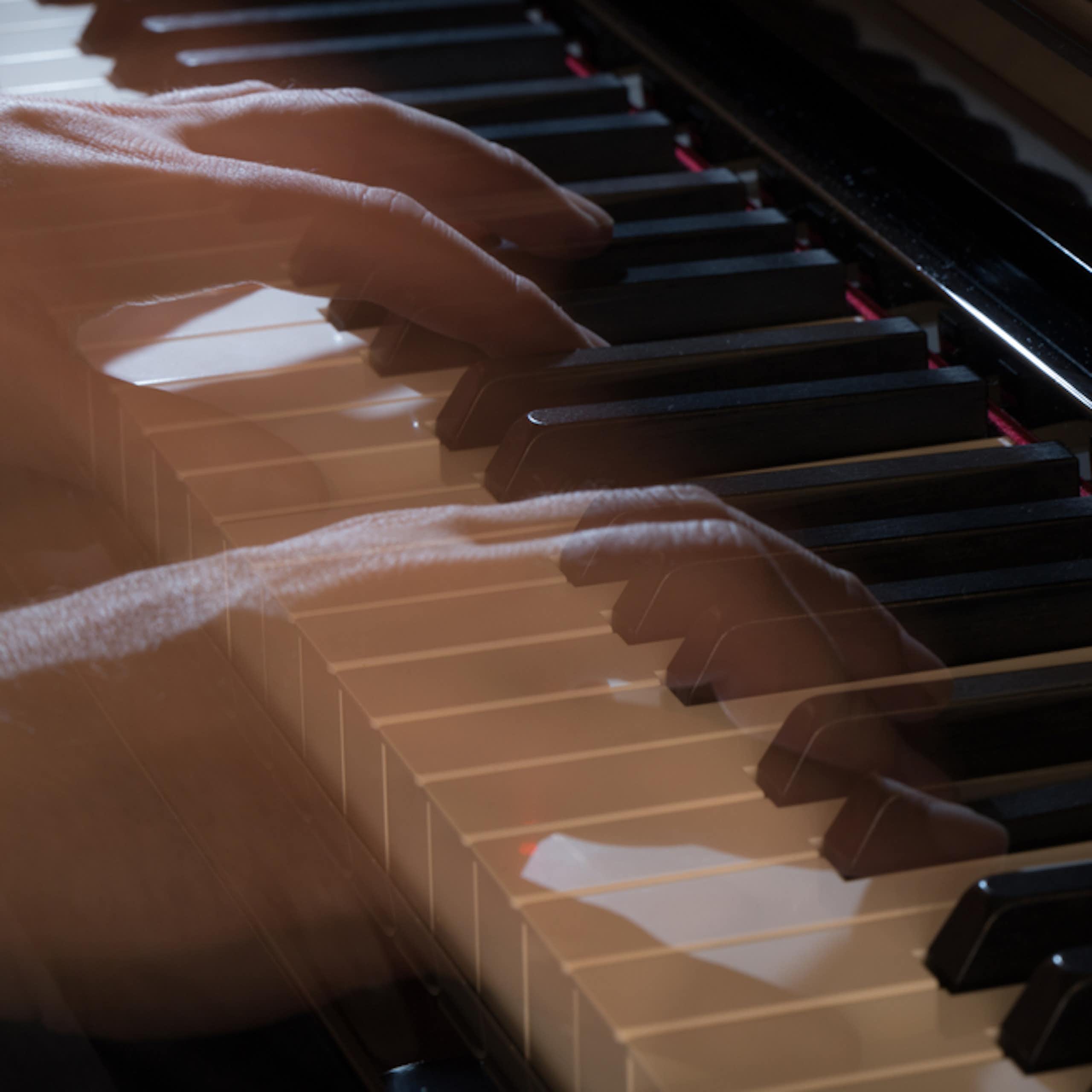 Mãos transparentes e fantasmagóricas tocam um piano.