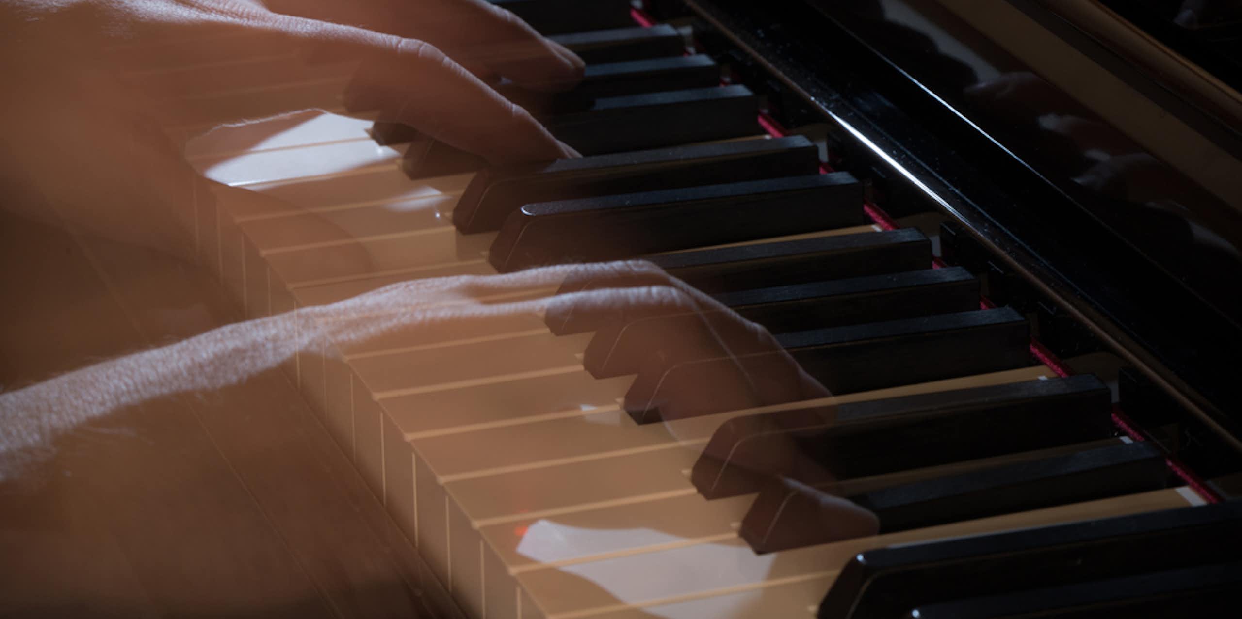 See-through, ghostly hands play a piano.