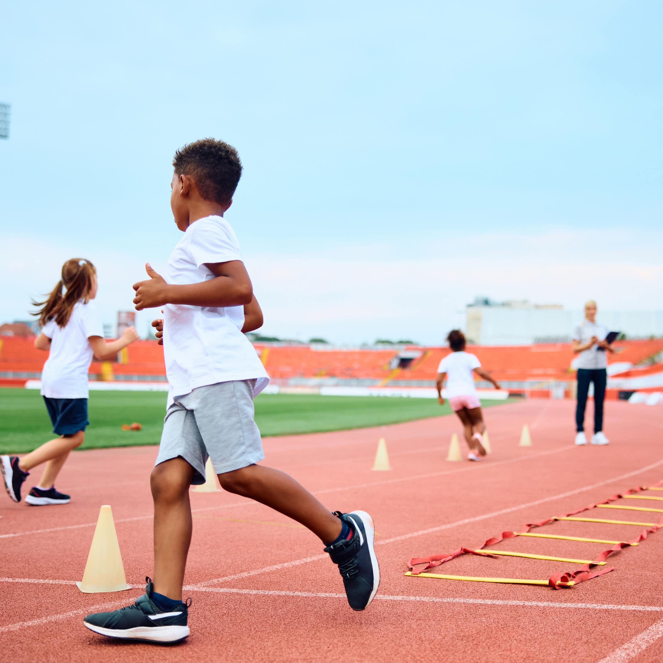 Children enjoy running games at an athletics track