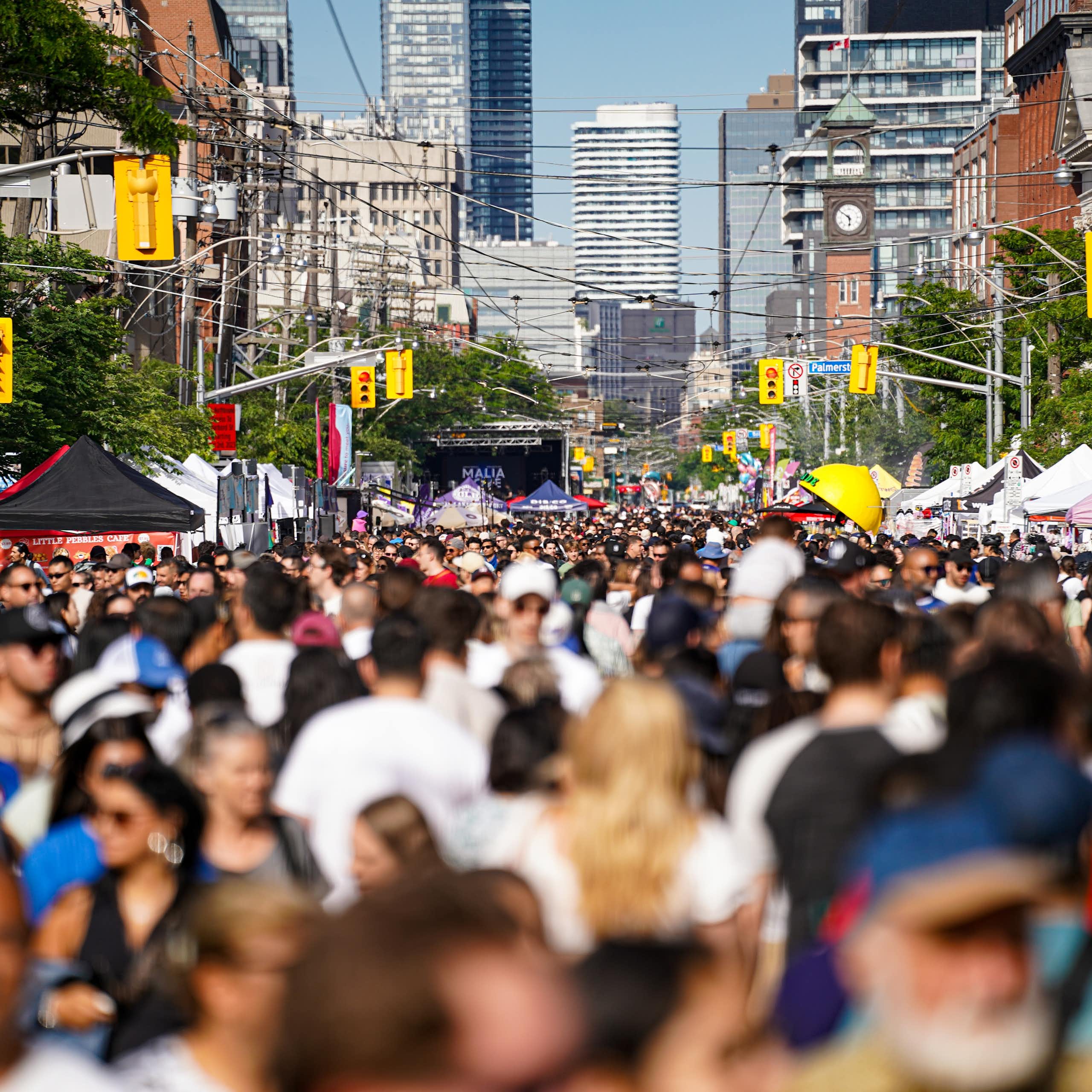 Une foule dans une rue, avec des édifices en arrière-plan