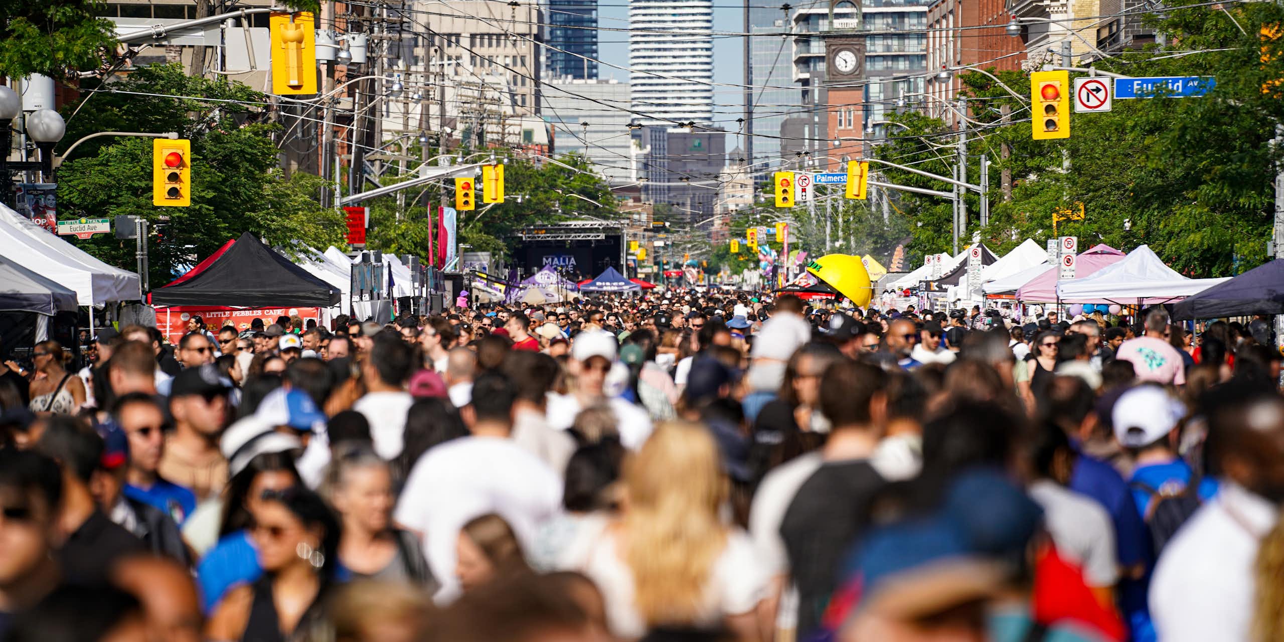 Une foule dans une rue, avec des édifices en arrière-plan