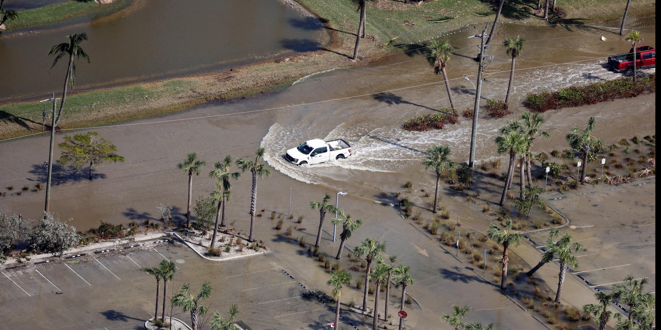 Una vista aérea de un automóvil que conduce a través de una calle inundada