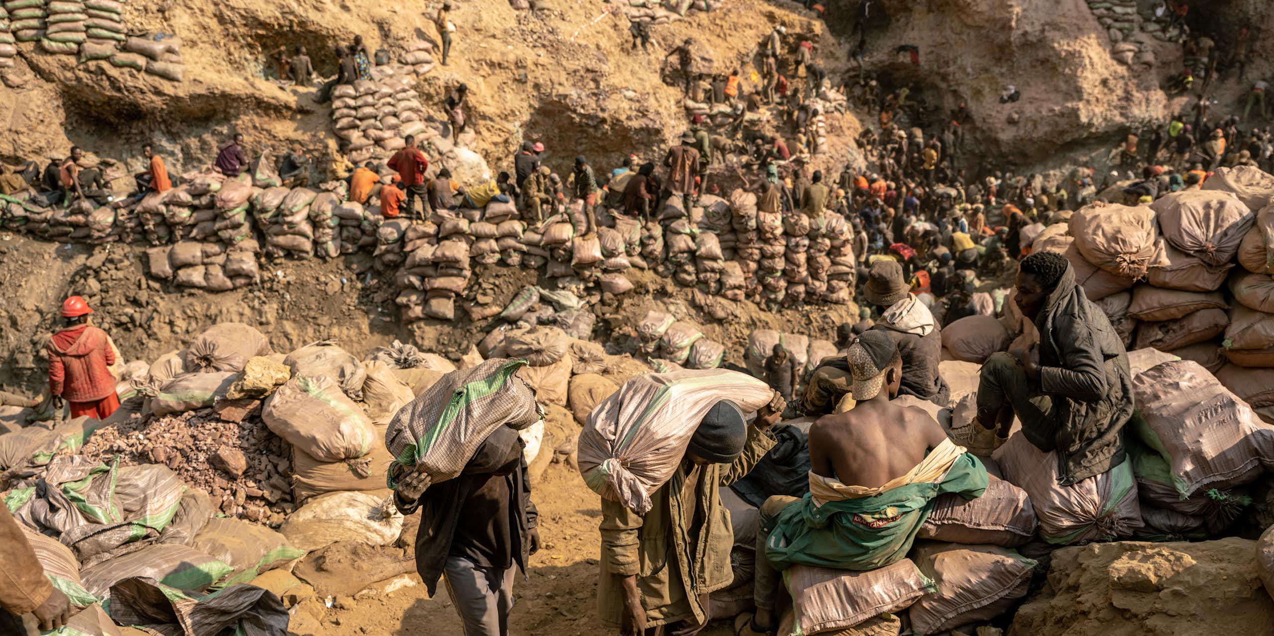 Miners carry bags of ore in the copper-cobalt Shabara artisanal mine near the town of Kolwezi, Lualaba, Democratic Republic of Congo.