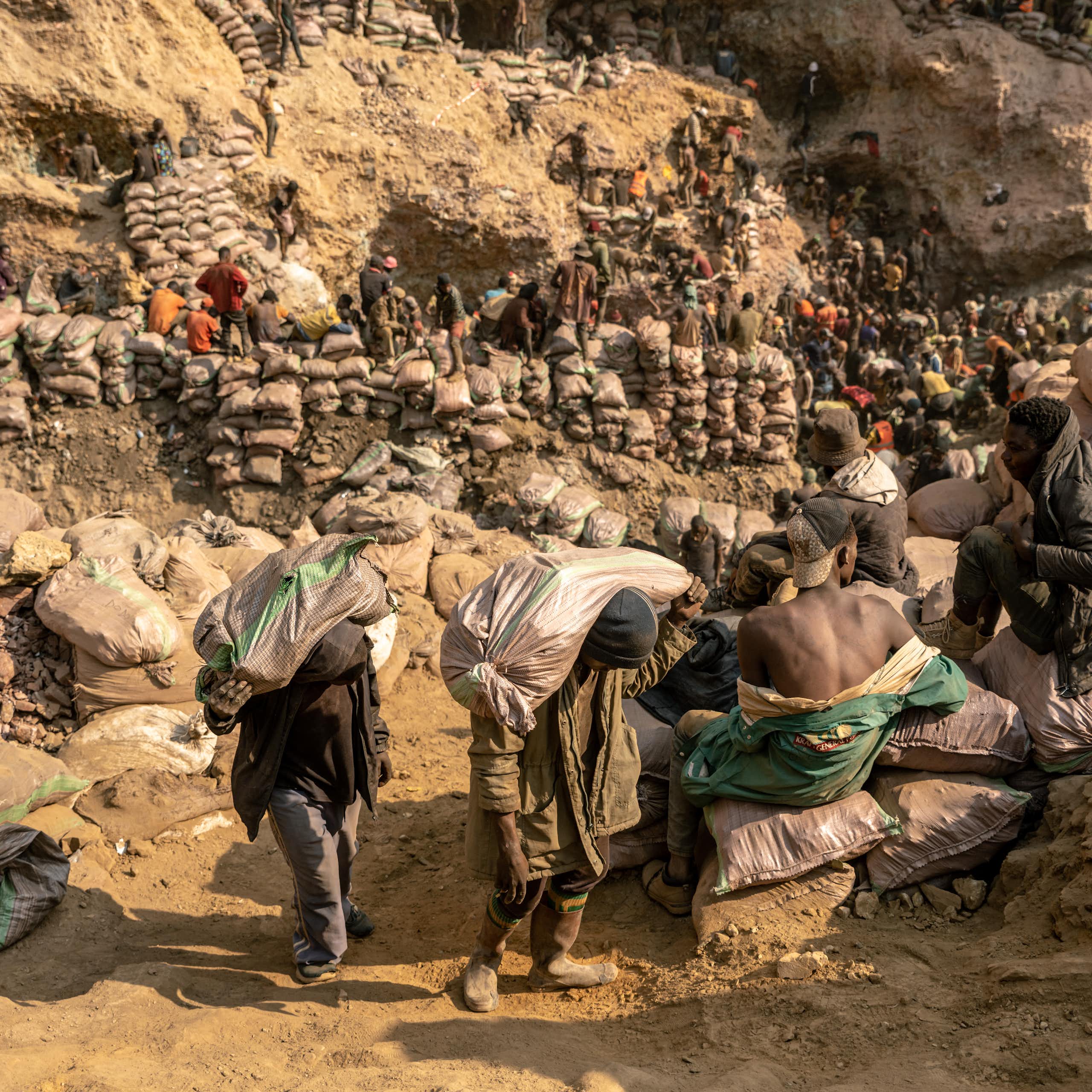 Miners carry bags of ore in the copper-cobalt Shabara artisanal mine near the town of Kolwezi, Lualaba, Democratic Republic of Congo.