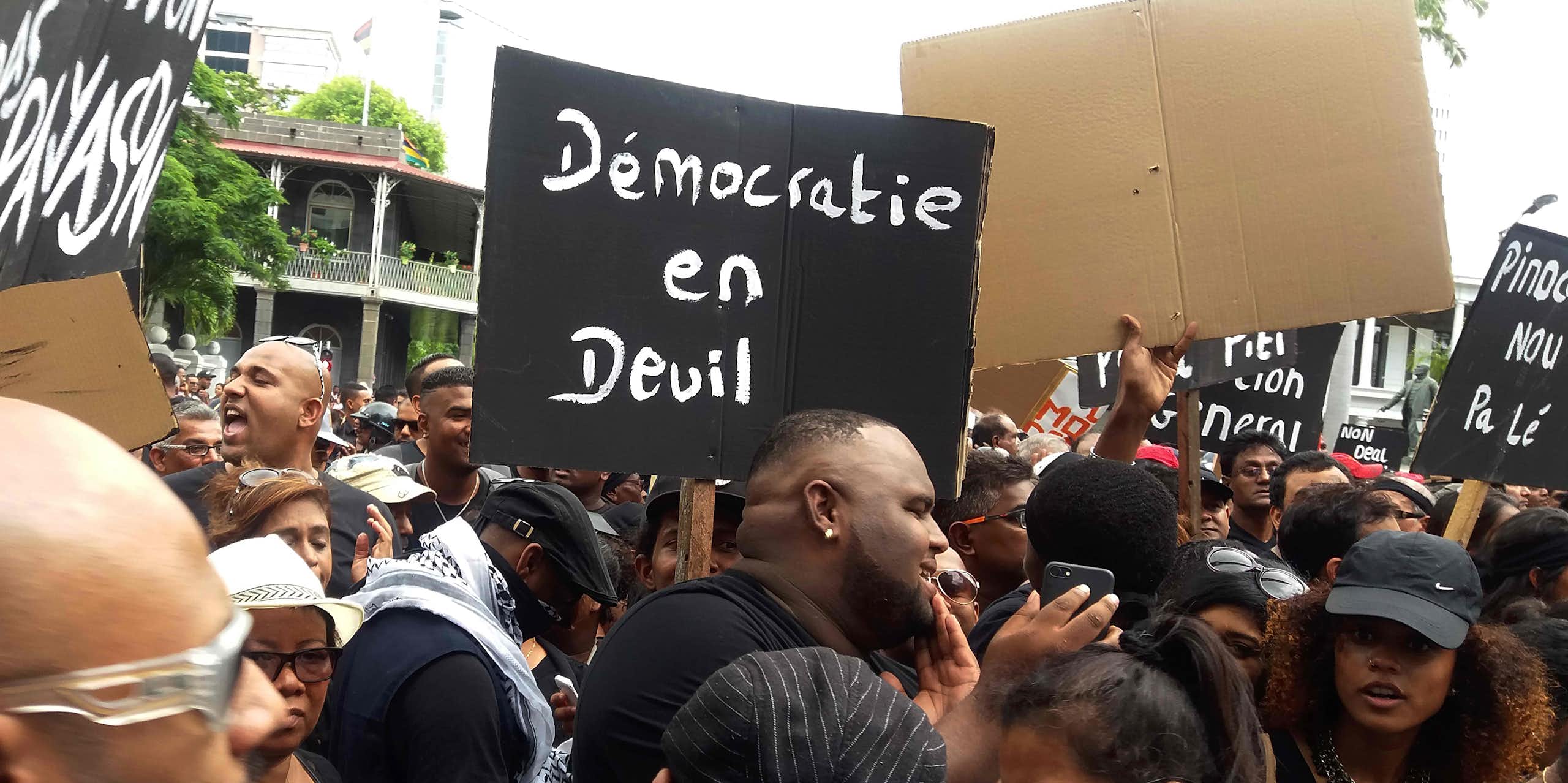 Protesters hold a placard reading 'Democracy in distress'