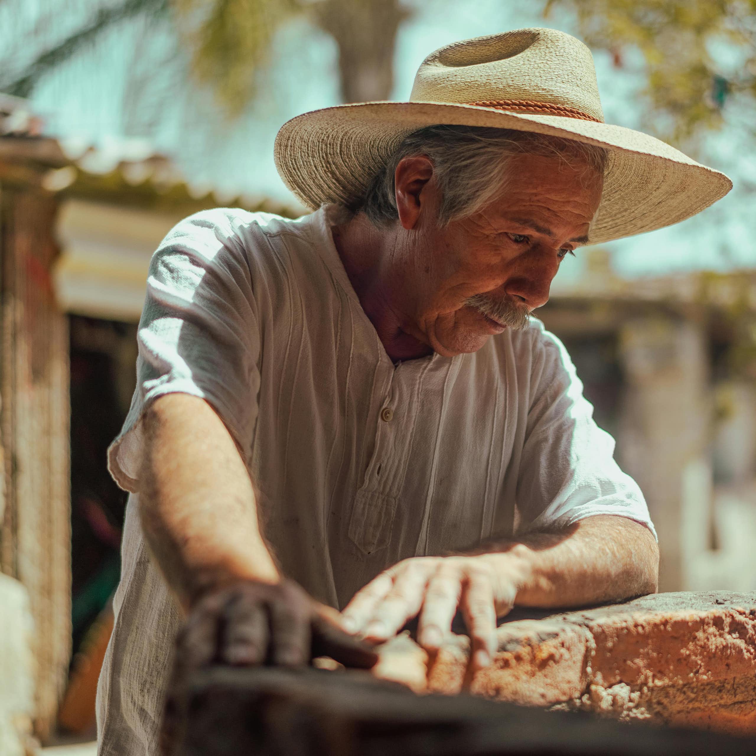 A senior man outdoors wearing a hat.