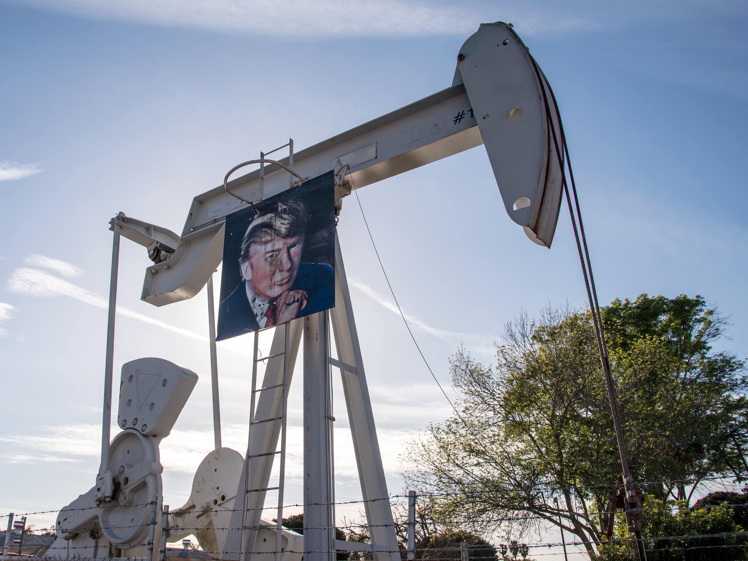 Huntington Beach, Californie - 24 janvier 2017. Des travailleurs du secteur pétrolier célèbrent la victoire présidentielle de Donald Trump et le renouvellement de son partenariat avec l'industrie pétrolière en accrochant sa photo sur les pompes à pétrole.