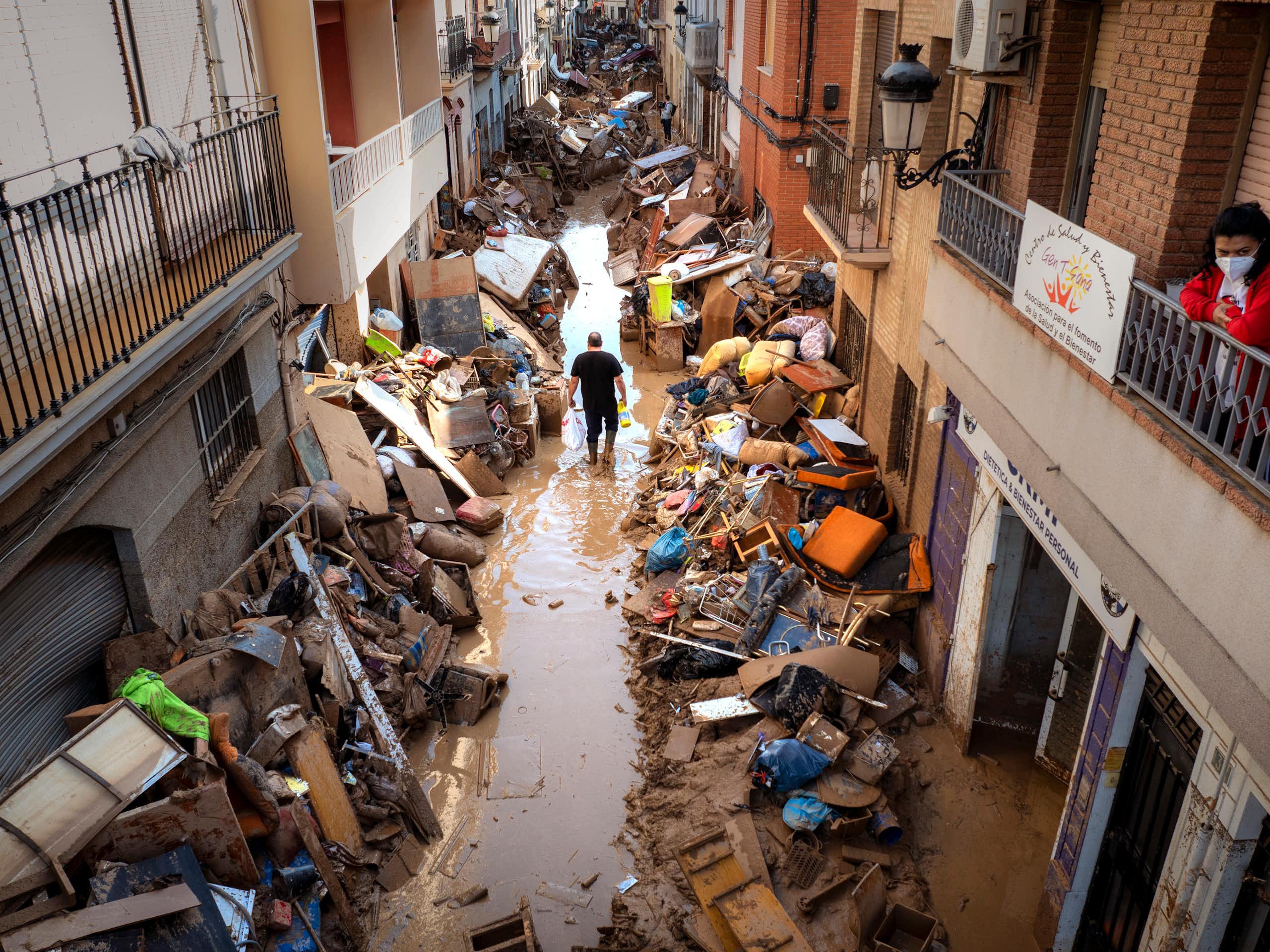 man walking flooded street spain