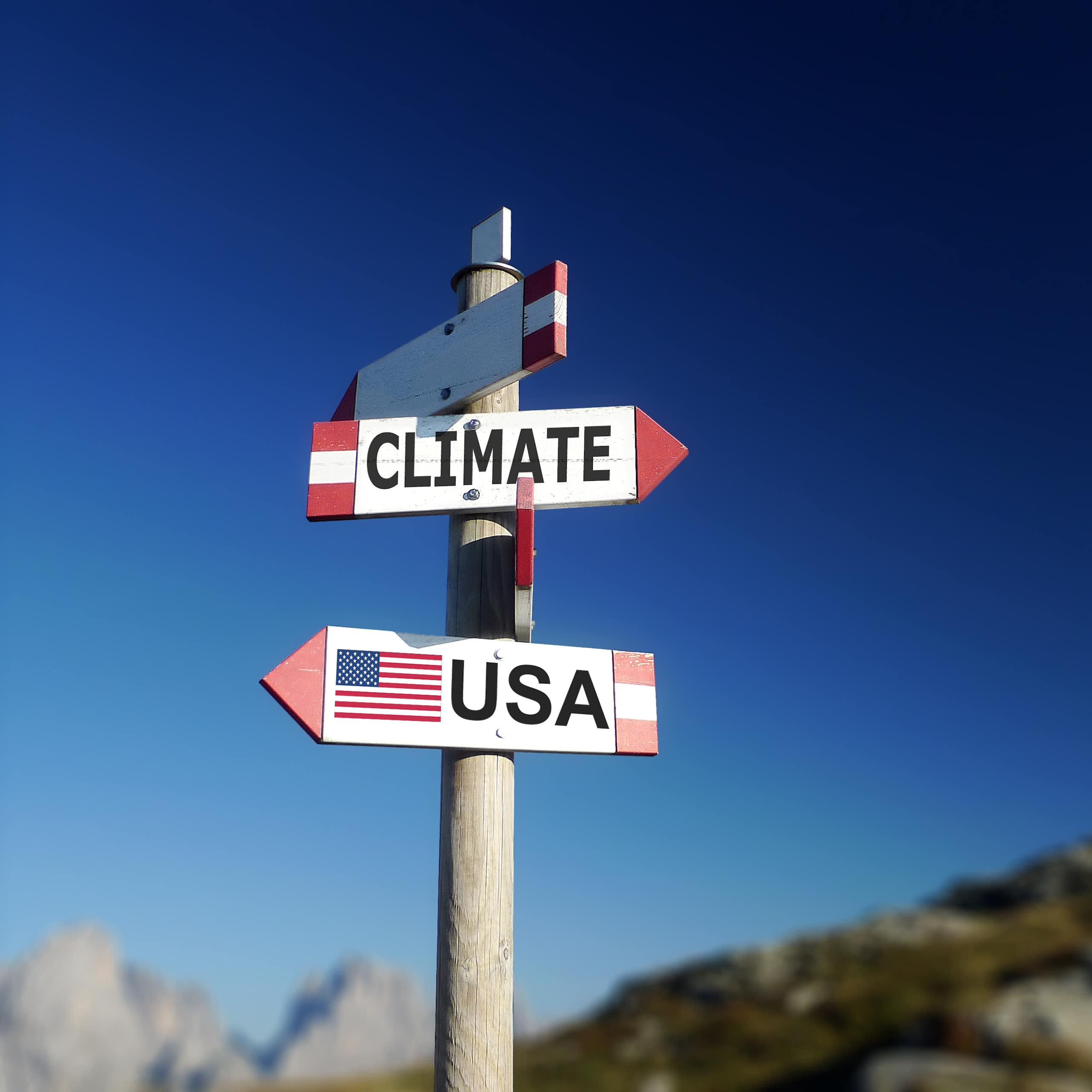 Road sign pointing to climate and USA in two different directions