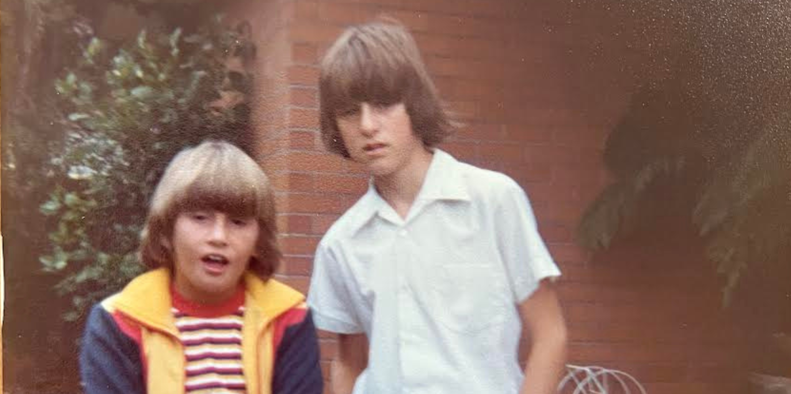 Two boys in the 1970s in a suburban backyard.